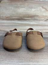 Tan toddler moccasins with brown straps and buckles on wood background