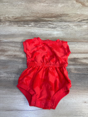 Top-down view of red Cat and Jack terry star romper 0-3M with sleeves, elastic waist and three snap closures on wood floor