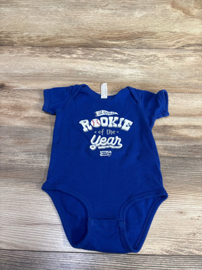 Top view of blue Rabbit Skins 12M bodysuit with Rookie of the Year front print and snap closures on wood background
