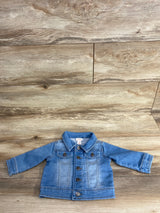 Light blue denim baby jacket with button closures and chest pockets on wooden background