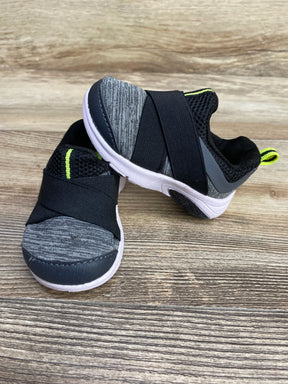 Kids slip-on sneakers, gray with black strap and neon trim, on wood background
