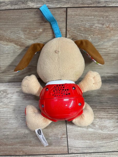 Back view of Vtech Cuddle And Sing Puppy showcasing red speaker unit with wooden floor background