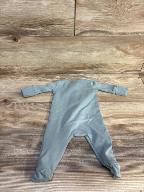 Flat lay of sage Colored Organics newborn sleeper showing back with footed legs and fold over cuffs on wood grain background