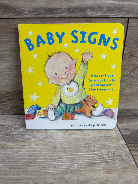 Front cover of Baby Signs board book featuring an illustrated baby and teddy bear on a yellow cover about sign language