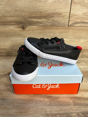 Black Cat & Jack kids sneakers with white soles on branded shoe box, wood background