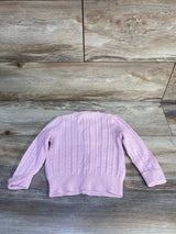 Back view of Ralph Lauren mini cable-knit cardigan in light pink showing cable stitch and ribbed hem and cuffs on wood floor