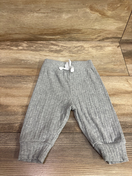 Top-down view of Shein gray ribbed drawstring joggers, size 1 to 3 months, showcasing cuffed ankles on a wood surface