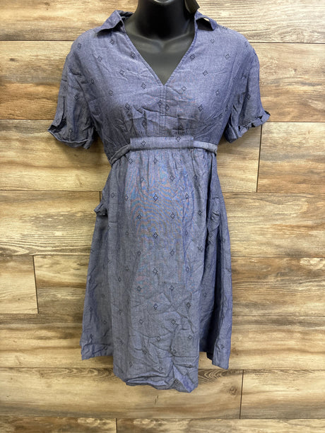 Front of blue chambray shirtdress with V-neck, empire waist belt and cuffed short sleeves on mannequin against wood backdrop