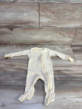 Flat lay of Member's Mark footed sleeper in pale yellow and white stripes showing front zipper and fold-over cuffs on wood background