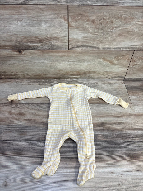 Flat lay of Member's Mark footed sleeper in pale yellow and white stripes showing front zipper and fold-over cuffs on wood background