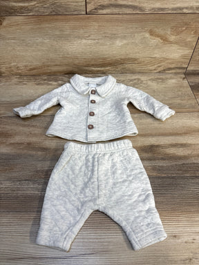 Light grey baby outfit with button-up jacket and matching pants on wood background