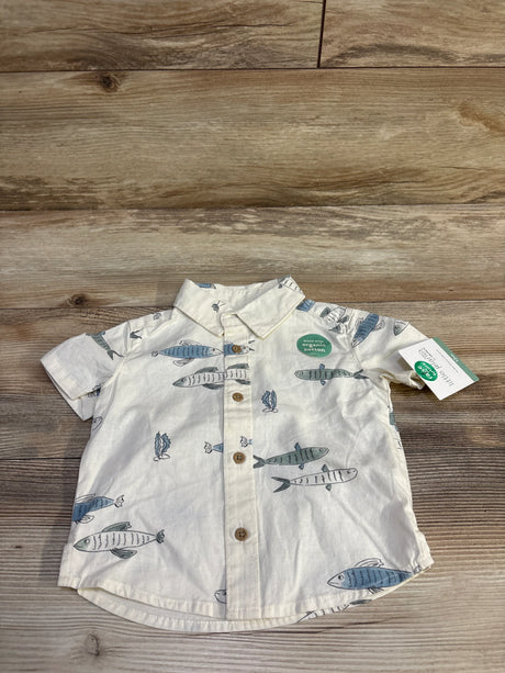 Flat lay of Little Planet ivory button-up baby shirt size 12 months showing blue fish print and wooden buttons on wood
