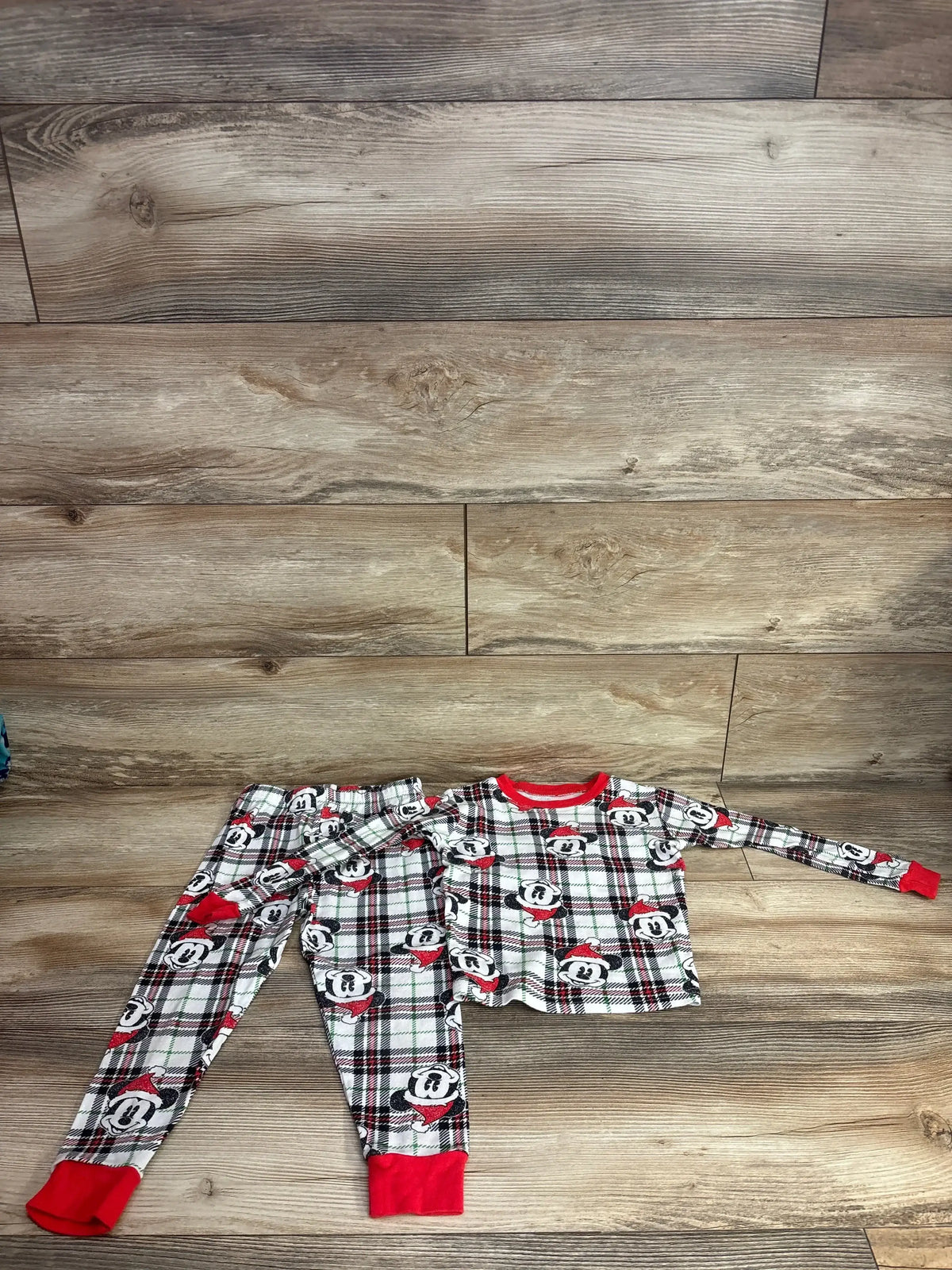 Mickey Mouse holiday plaid pajama set for kids, red trim, festive Christmas sleepwear on wood floor