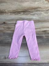 Flat lay of girls' Old Navy pink ribbed leggings showing ribbed texture and ruffled hems on wood background