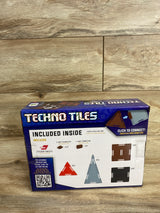Techno Tiles building set box showing included connectors, triangle and square tile pieces on wood floor.