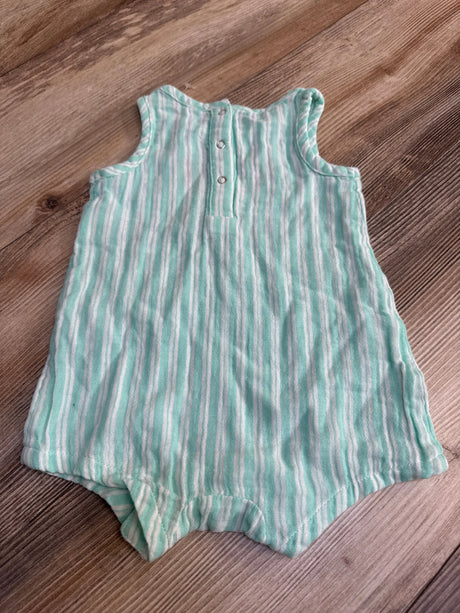 Green and white striped sleeveless baby romper with buttons, laid on wooden floor