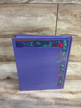 Upright Disney Beauty and the Beast hardcover book showing purple cover with rose vine border on a light wood surface