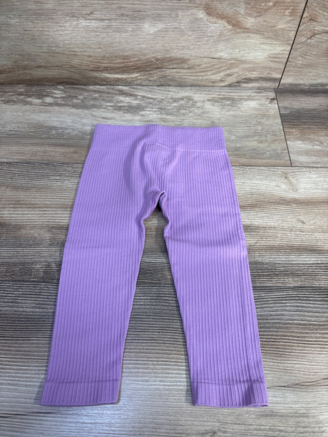 Flat lay of lilac toddler ribbed leggings (12–24 months) showing ribbed texture and elastic waistband on wood floor background