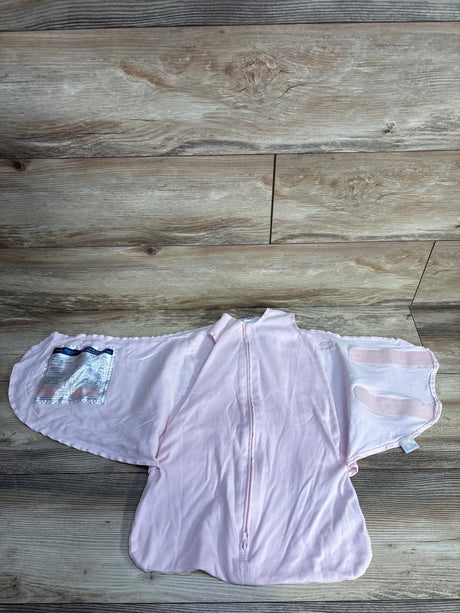 Light pink baby swaddle blanket with zipper and velcro straps on wood floor