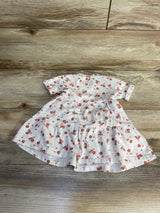 Baby girl floral dress with short sleeves and red flower print on wood background