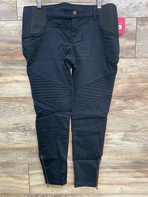Black moto biker pants with ribbed knee panels and ankle zippers on wooden floor