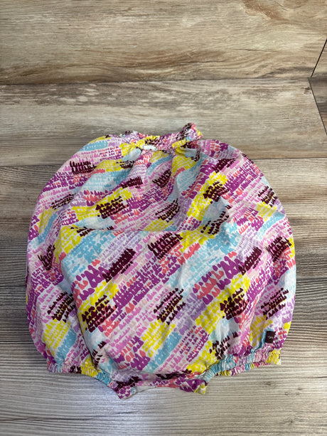 Top view of sleeveless bubble romper with pink multicolor abstract print and elasticized neckline and legs on wood floor