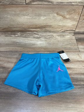 Front view of Air Jordan mesh shorts in bright blue size 12 months, elastic waistband and pink Jumpman on wood background