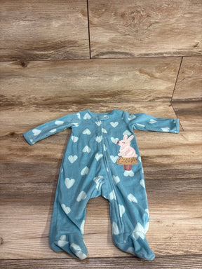 Blue baby sleeper with white heart pattern and bunny patch, footed, laid on wood floor