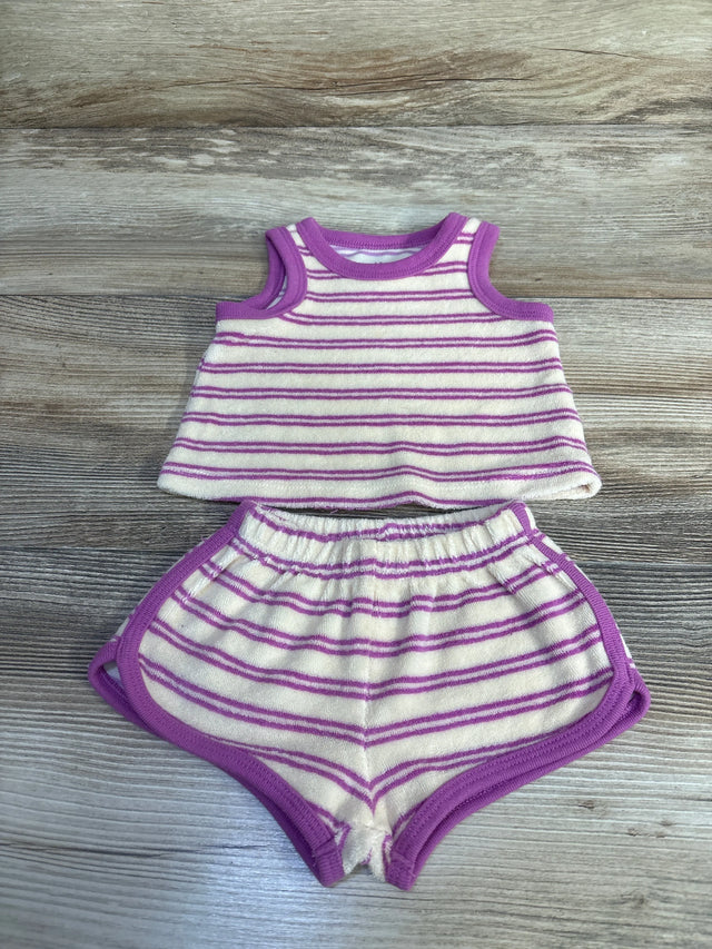 Top-down flat lay of newborn terry cloth tank top and shorts showcasing ivory with purple stripes and trim on wood background