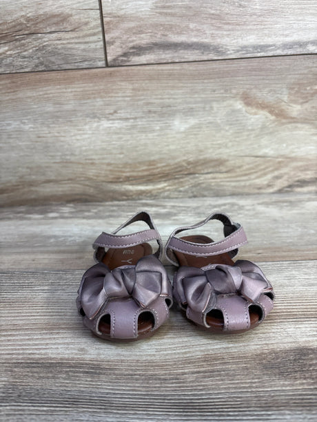 Front view of EYY mauve toddler sandals showcasing knotted bows, open-toe cutouts and ankle straps on light wood background