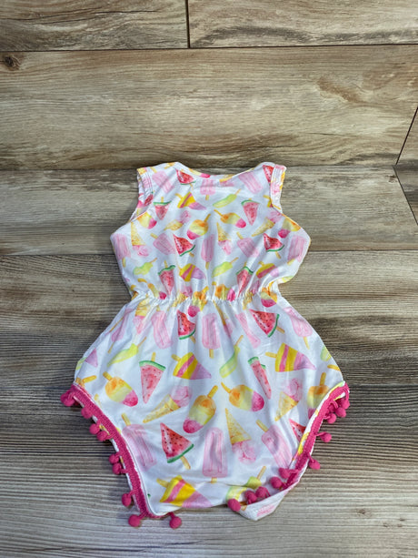 Front flat-lay of white baby romper with pastel popsicle and watermelon print, elastic waist, hot-pink pom-pom trim on wood floor