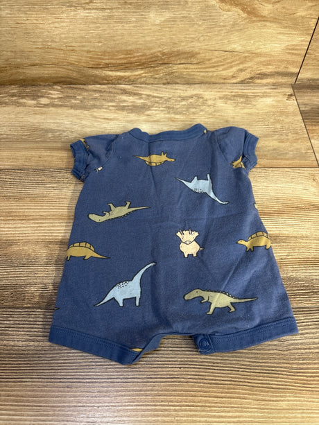 Flat-lay back view of blue newborn short romper with dinosaur print and leg snaps on wood surface