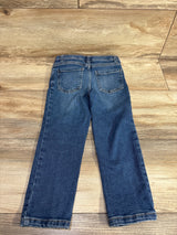 Children's blue denim jeans with back pockets on wooden floor background