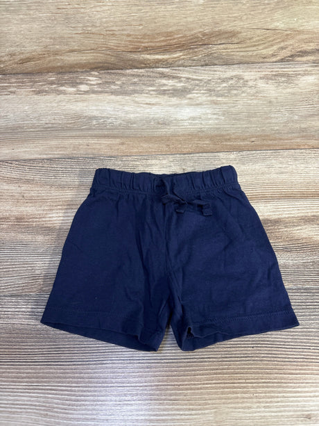 Flat lay of navy H&M baby shorts showcasing elastic pull-on waist and tied drawstring on light wood background