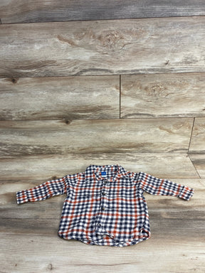 Plaid long-sleeve baby shirt with button front in blue, red, and white on wood floor.