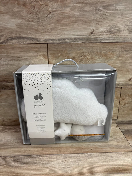 Front view of Just Born musical mobile showcasing sparkly gray stars in clear packaging on a wood surface