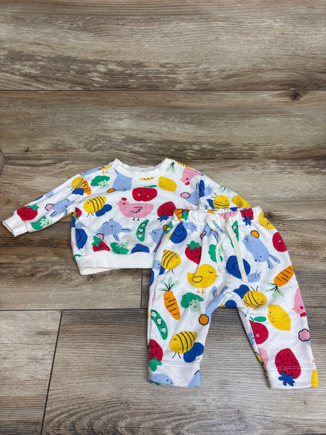 Flat lay of an Old Navy pullover sweatshirt and pants set in white with colorful fruit and animal print on wood flooring