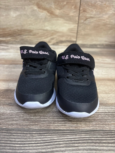 Front view of U.S. Polo Assn. black glitter sneakers showcasing black laces and white soles on a wood-grain surface