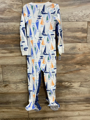 Children's white footed pajamas with colorful sailboat print on wooden floor