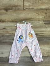 Front view of pink Bluey floral newborn jumpsuit with ruffle sleeves, character prints, and snap leg closures on wood floor