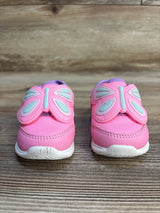 Pink toddler sneakers with butterfly wing details on wooden surface