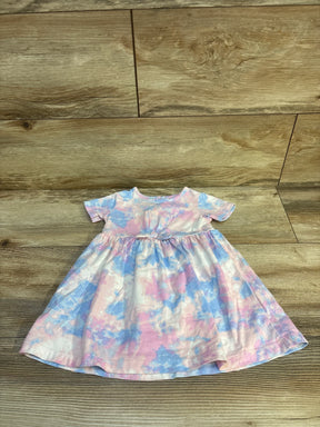 Flat lay of Carter's short-sleeve baby dress showing pink and blue tie-dye pattern and gathered waist skirt on wood plank background