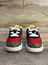 Kids' red and black sneakers with fruit print, white laces, yellow accents on wood floor
