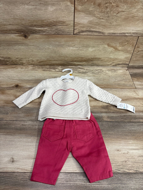 Flat lay of Carters 2pc knit sweater and pants set showcasing an ivory heart sweater and burgundy pants on wood flooring