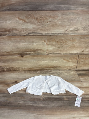 White long-sleeve baby girl cardigan with a single button and price tag on wood background