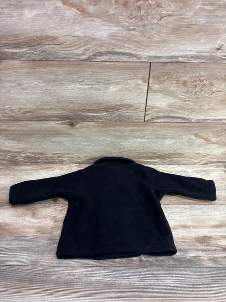 Flat lay of a black Starting Out fleece peacoat showing its collar and long sleeves on a wood-look floor