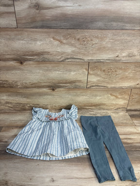 Striped blue toddler dress with floral embroidery and matching blue leggings on wood background