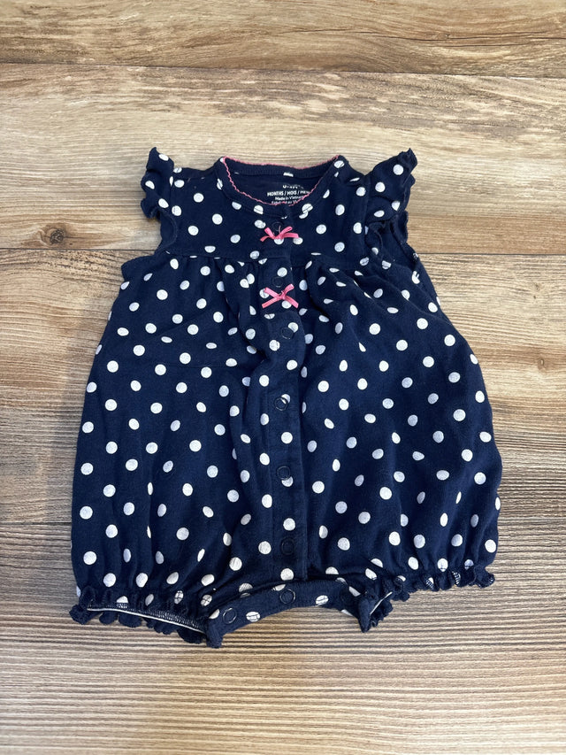 Navy blue baby romper with white polka dots and pink bows on wood background