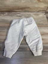 Flat lay front view of cream H&M baby joggers size 3 months showcasing elastic waistband and ribbed ankle cuffs on wood floor