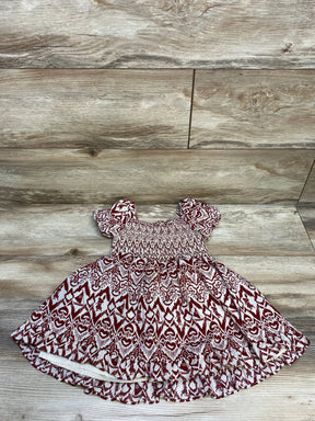 Cute toddler dress with red and white tribal pattern and puff sleeves on wooden floor